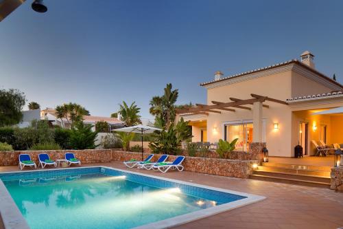 a villa with a swimming pool and a house at Casa Dos Cedros in Carvoeiro