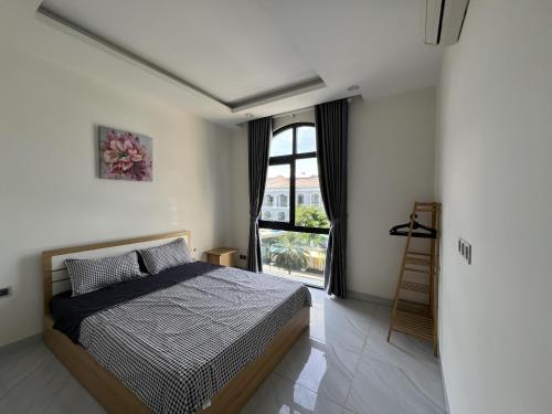 a bedroom with a bed and a large window at Sua Chua in Phú Quốc
