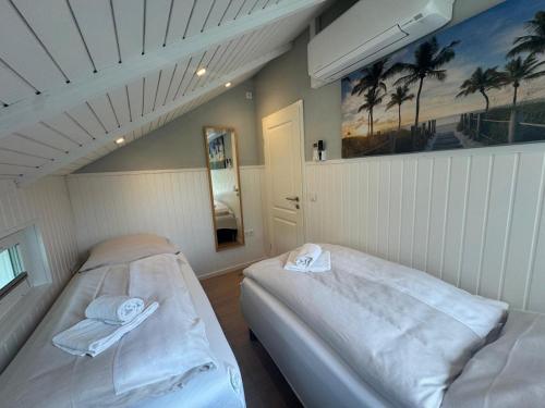 グリュックスブルクにあるDreibogen Ferienhaus Smalandのヤシの木がある白い部屋のベッド2台