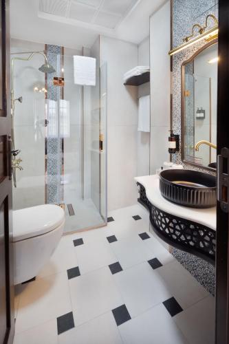 a bathroom with a toilet and a shower and a sink at Sırçalı Hotel in Meram
