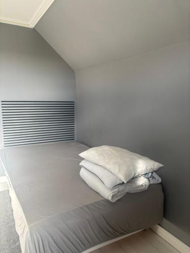 a bed with white sheets and pillows in a room at Villa Fredsstigen in Åmål
