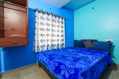 um quarto azul com uma cama e uma cómoda em Butterfly homestay em Ooty