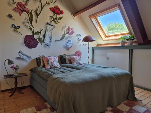 a bedroom with a bed with flowers on the wall at Vakantiehuis Joghmanstuin in Kapel-Avezaath