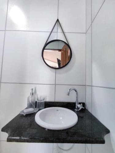 a bathroom with a sink and a mirror at Chalé Bella Vista in Mulungu