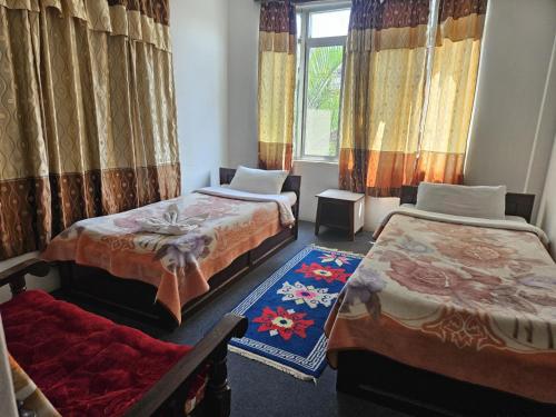 a room with two beds and a window at Elegant Guest House in Pokhara