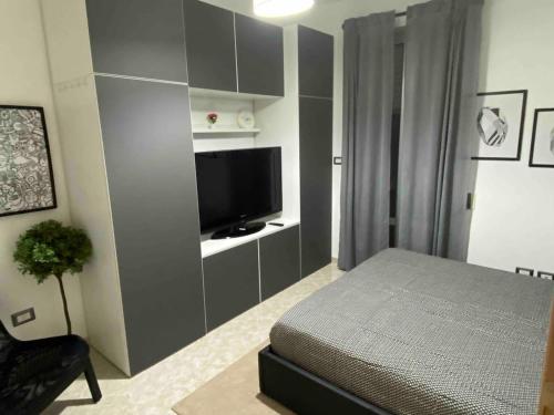 a bedroom with a bed and a flat screen tv at Modern apartment - Salento Guest House in Monteroni di Lecce