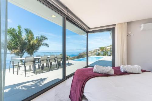 ein Schlafzimmer mit Bett und Blick auf das Meer in der Unterkunft Villa Zenha by Atlantic Holiday in Ribeira Brava
