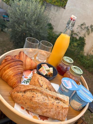 Een bord met brood en toast op tafel, met drankjes erbij. bij Maison cosy - Entre les deux collines in Saint-Michel-sur-Savasse