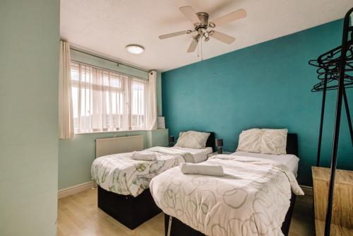 two beds in a room with a ceiling fan at Spacious Tilbury Home - Perfect for Contractors, Families, Groups in East Tilbury