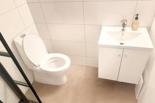a white bathroom with a toilet and a sink at Cozy private house with free parking in Kongsvinger