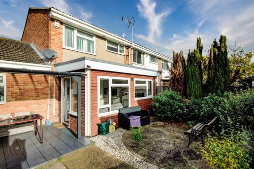 a home with a patio with a bench in the yard at Spacious Tilbury Home - Perfect for Contractors, Families, Groups in East Tilbury