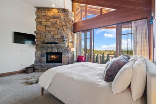a bedroom with a large bed and a fireplace at RMR: Crystal Springs 401 Condo in Teton Village in Teton Village