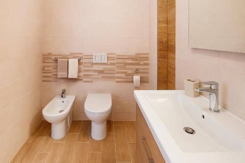 a bathroom with a toilet and a sink and a tub at Wald Haus Tarvisio in Tarvisio