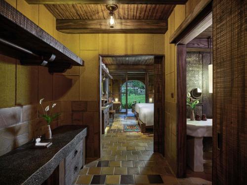 a hallway of a house with a bathroom and a sink at Legacy Yen Tu - MGallery in Uông Bí