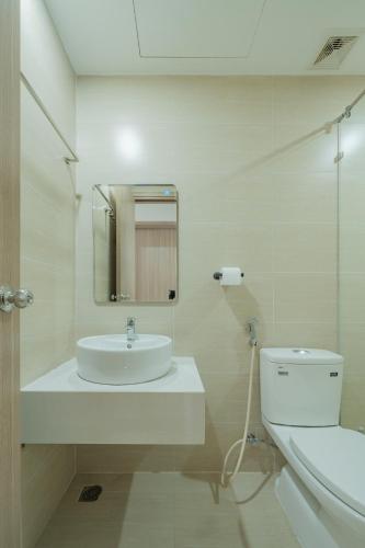a white bathroom with a sink and a toilet at Hue Rustic Homestay with Swimming Pool & Gym Room in Thôn Văn Dương