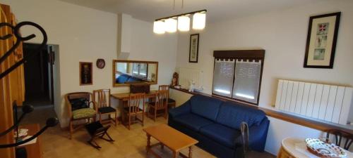 un soggiorno con un divano blu e un tavolo di Casa De Los Abuelos a Ortigosa del Monte