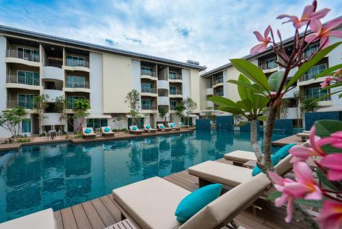 a hotel swimming pool with lounge chairs and a resort at Mercure Langkawi Pantai Cenang in Pantai Cenang