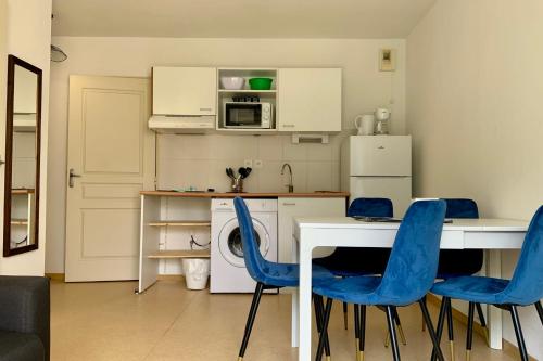 a kitchen with a white table and blue chairs at Les Naïades I49 - 2 bedrooms for 5 people ! in Avène