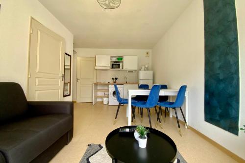 a living room with a couch and a table and blue chairs at Les Naïades I49 - 2 bedrooms for 5 people ! in Avène
