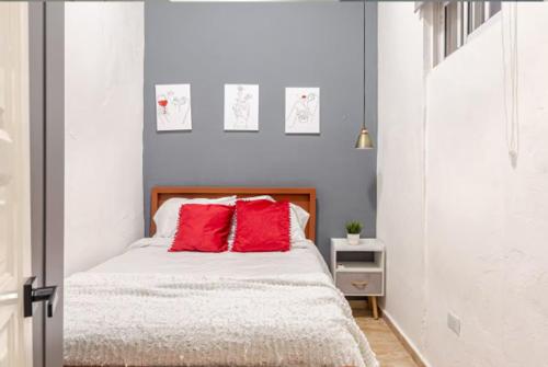 une chambre avec un lit avec des oreillers rouges dans l'établissement SDQ Colonial Zone an great find, à Saint-Domingue