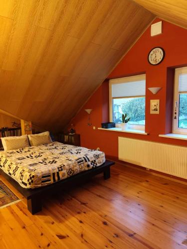 ein Schlafzimmer mit einem Bett und einer Uhr an der Wand in der Unterkunft Studija viloje-Quiet Apartment 15 min from Airport in Kaunas