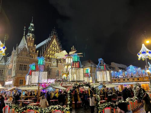 un mercado de Navidad frente a un edificio con luces de Navidad en NiceOne Apartment Number 9 - W samym Centrum!, en Wroclaw