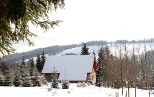 a house with a snow covered roof in the snow at Chata Béďa in Bedřichov