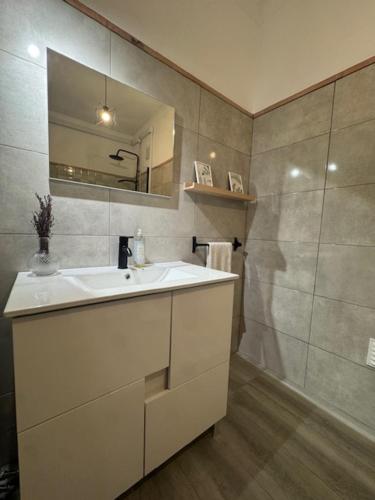 een badkamer met een witte wastafel en een spiegel bij Apartamento Central Rainha in Caldas da Rainha
