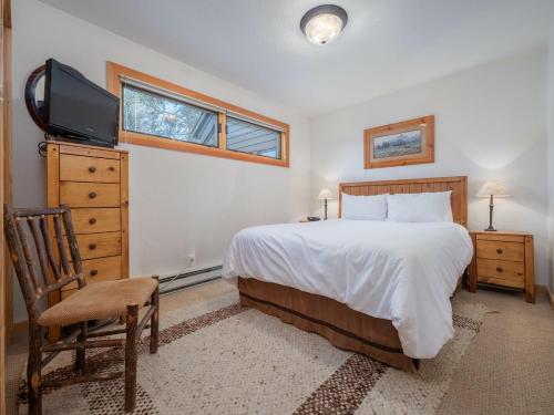 a bedroom with a bed and a tv and a chair at RMR: Cedars 1412 Condo in The AspensWilson WY in Wilson