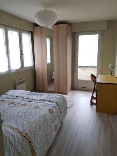 a bedroom with a bed and a desk and windows at L'appart du bonheur à Reims in Jonchery-sur-Vesle