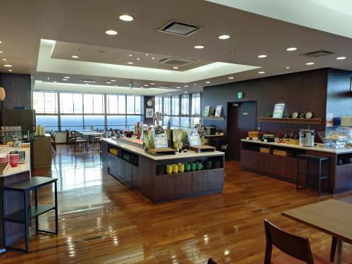 Un restaurante con mesas y sillas en una habitación. en Hotel Hokke Club Oita, en Oita