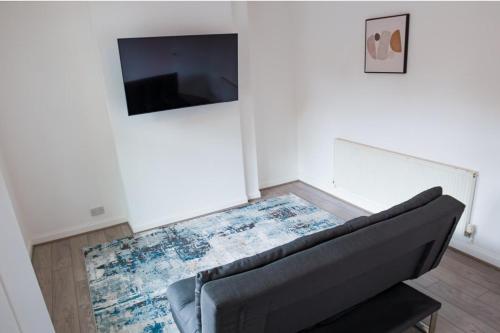 a living room with a couch and a flat screen tv at House Sleeps 6 - Parking Garden Family&Contractors in Walsall
