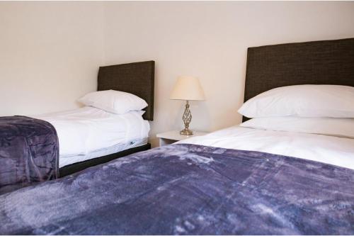 a bedroom with two beds and a table with a lamp at House Sleeps 6 - Parking Garden Family&Contractors in Walsall