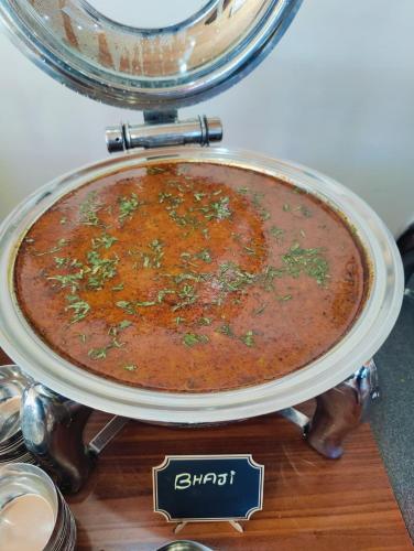 a dish of food in a cloche on a table at Aliza Inn And Suites By SRS Hotels in Dharamshala