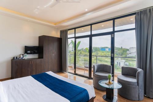 a bedroom with a bed and a large window at Sasa resort Udaipur in Udaipur