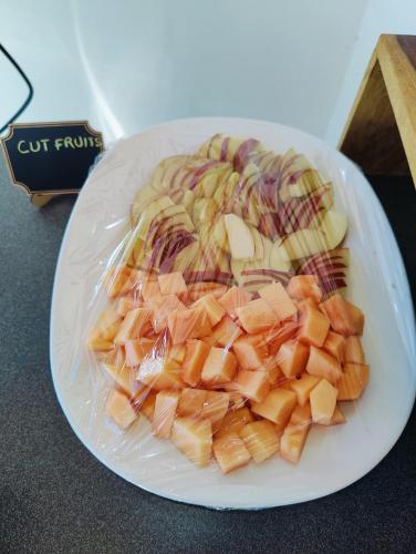 a plate of cut fruits on a table at Aliza Inn And Suites By SRS Hotels in Dharamshala