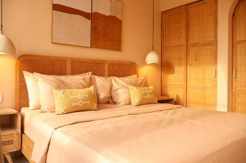 a bedroom with a large white bed with two pillows at Pasir 2 - A stylish 2 bed villa in Bingin w pool in Bingin Beach