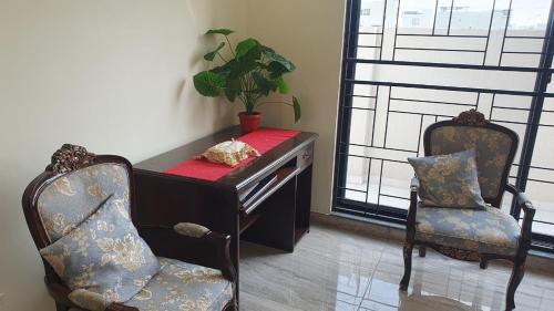 a desk and two chairs in a room with a plant at 3 bedroom modern house in Lahore