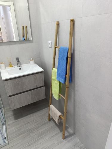 a bathroom with a towel rack next to a sink at Quintal do Olival- Um refúgio na Natureza in Lousã