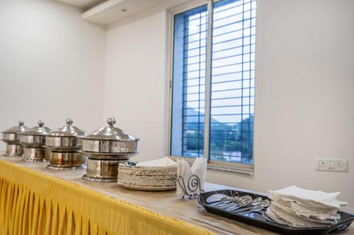 RourkelaTreebo Green Olive的一张摆放着银质餐具的桌子，旁边有一扇窗户