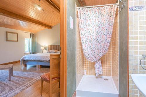 un bagno con doccia e una camera con un letto di Les Violettes De Malleville a Saint-Romain-de-Benet