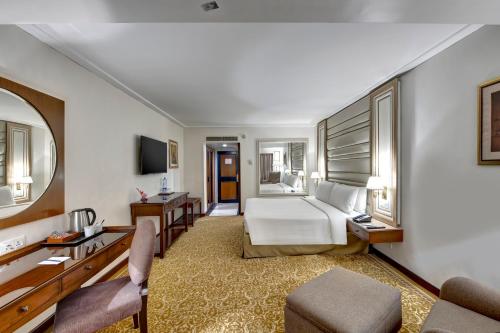 a hotel room with a bed and a desk at Pearl Continental Hotel, Karachi in Karachi