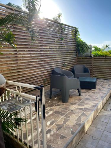un patio con 2 sillas y una valla en Résidence cannelle, en Les Trois-Îlets