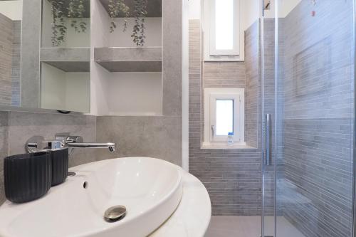 a bathroom with a white sink and a shower at PrimoPiano - Sempione in Milan