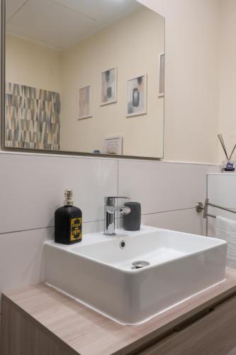 a bathroom with a white sink and a mirror at Naples Soul - city center in Naples