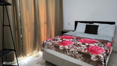 瓜拉廷格塔Chácara charmosa com piscina, campo de futebol的一间卧室,床上有红色玫瑰