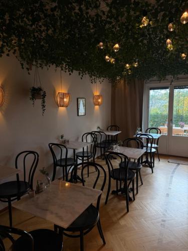 a restaurant with tables and chairs in a room at Ewa & Maude Hotel in Gothenburg