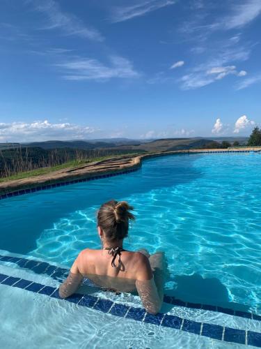 a woman is sitting in a swimming pool at Dargle Forest Lodge in Dargle