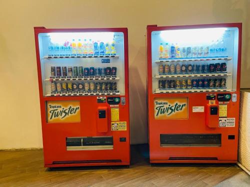 two orange soda machines sitting next to each other at Reizz Residence by Perkasa Suites in Batu Empat