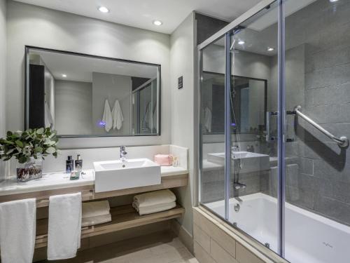 a bathroom with a sink and a shower at Pullman Santiago Vitacura in Santiago
